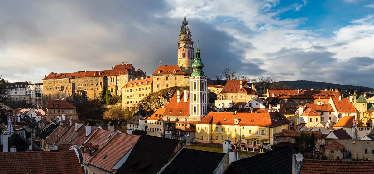 The Castle Tower above the red roofs of Český Krumlov at sunset.