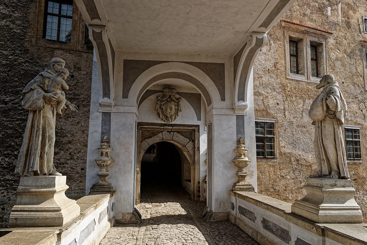 The covered passage of the Cloak Bridge at Český Krumlov Castle, lined with statues.