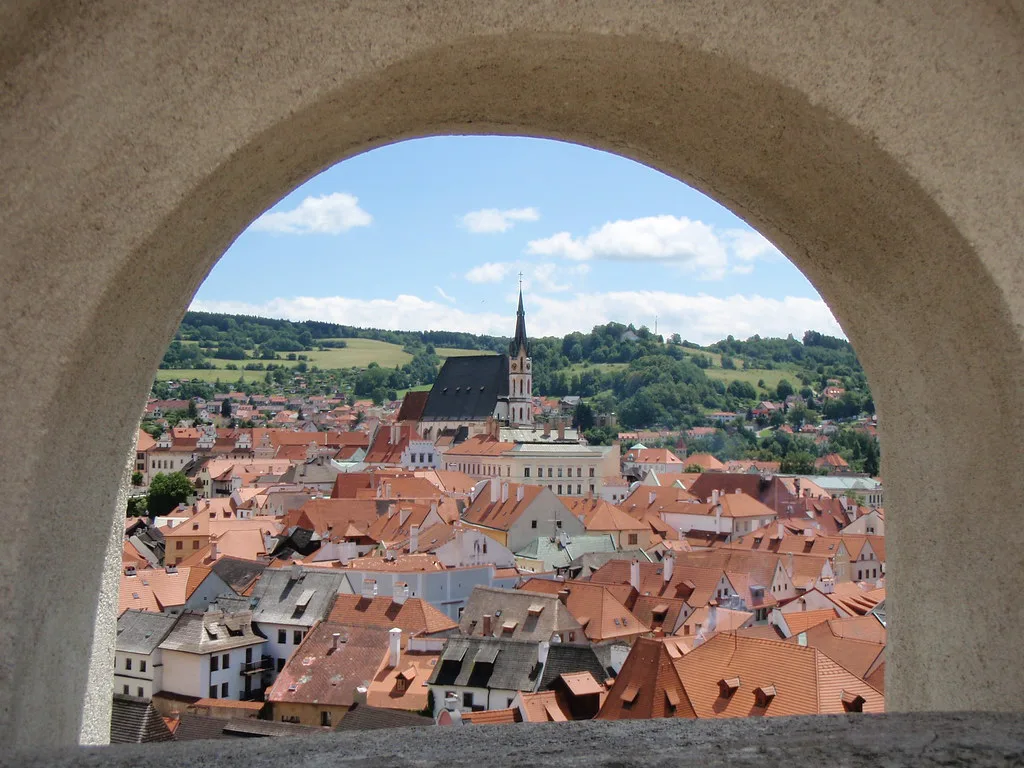 Český Krumlov rooftops seen through a stone arch