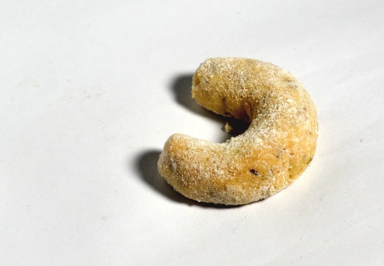 A single vanilla crescent cookie (vanilkový rohlíček).