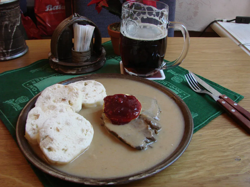 Svíčková with bread dumplings and cranberry sauce, served with a dark beer at U Fleků in Prague
