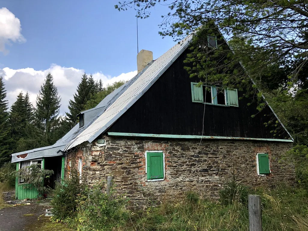 An abandoned stone house with a dark timber gable in Jáchymov