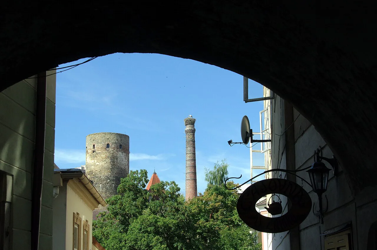 A castle tower in Jindřichův Hradec seen through a stone archway.