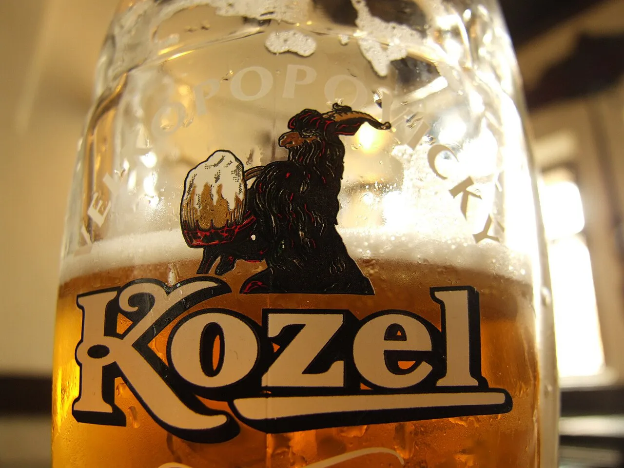 A glass of Kozel lager with the brewery's goat logo.