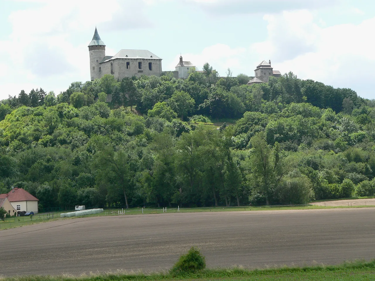Kunětická hora Castle on its wooded hill above the fields.