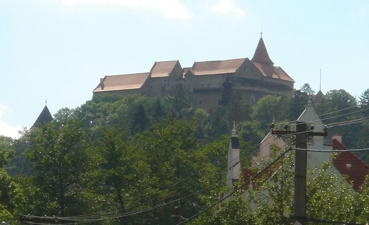 Pernštejn Castle rising above the trees.