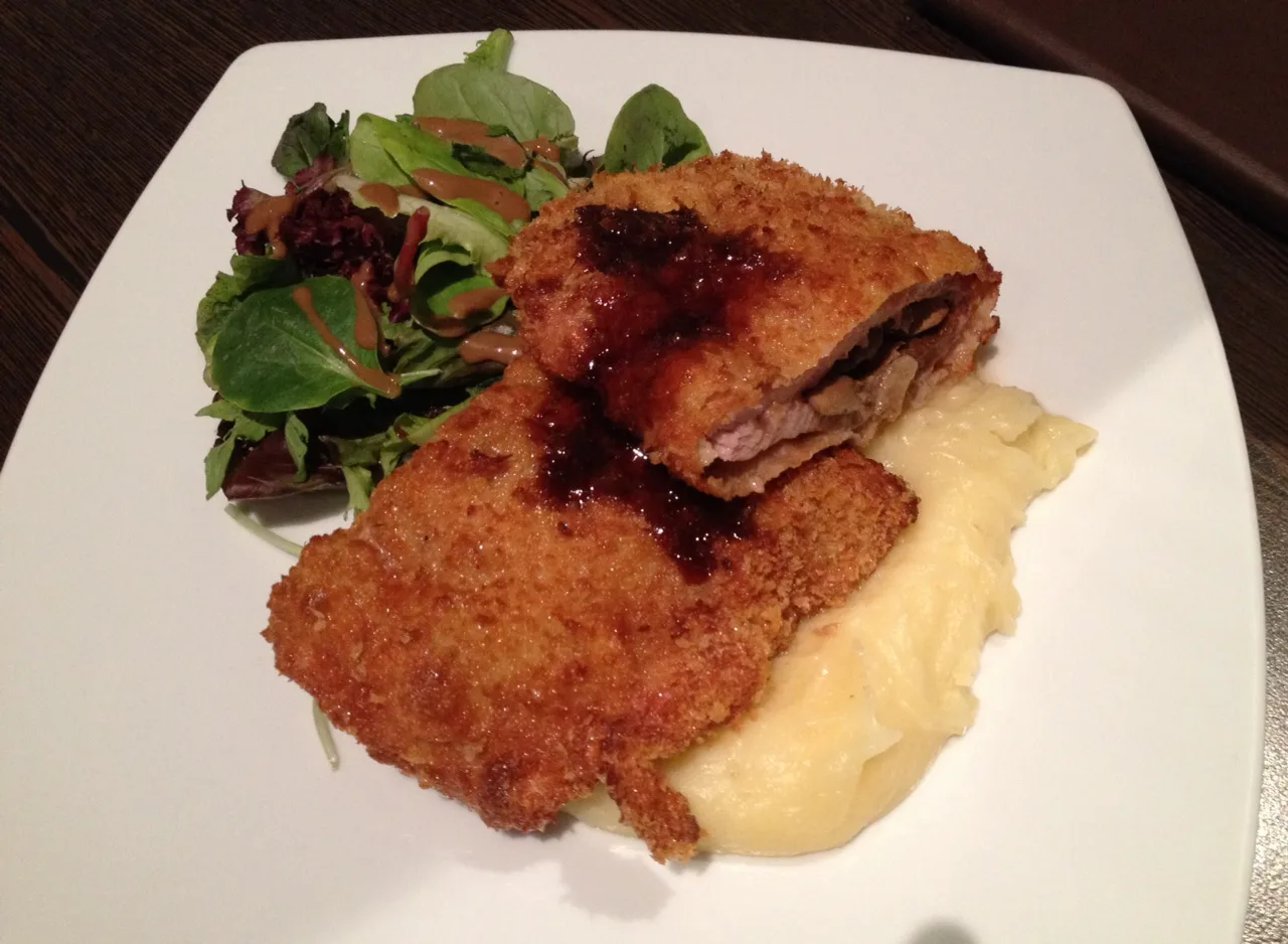 Pork schnitzel served with mashed potatoes and salad.
