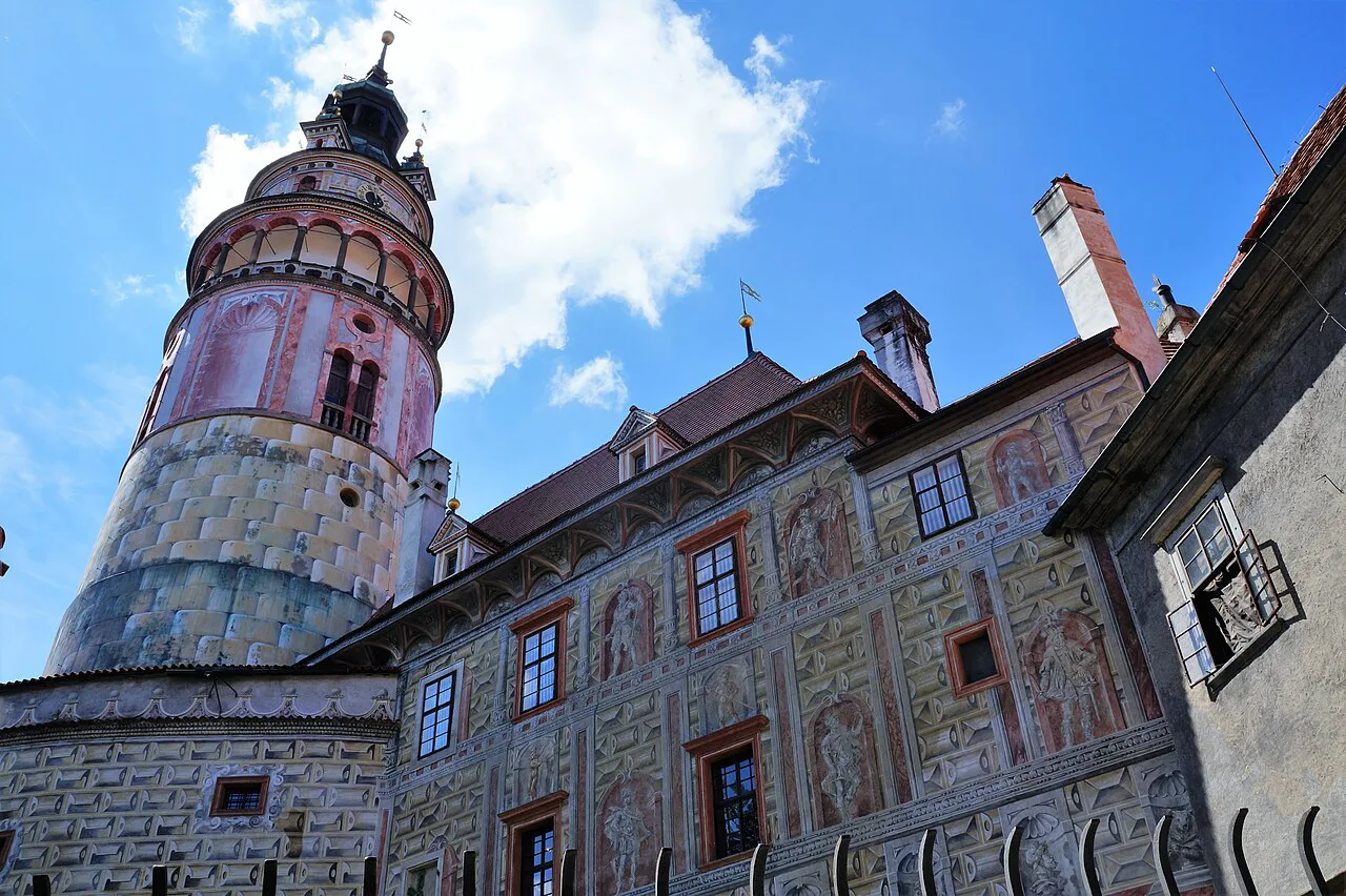 The round tower and painted facades of Český Krumlov Castle.