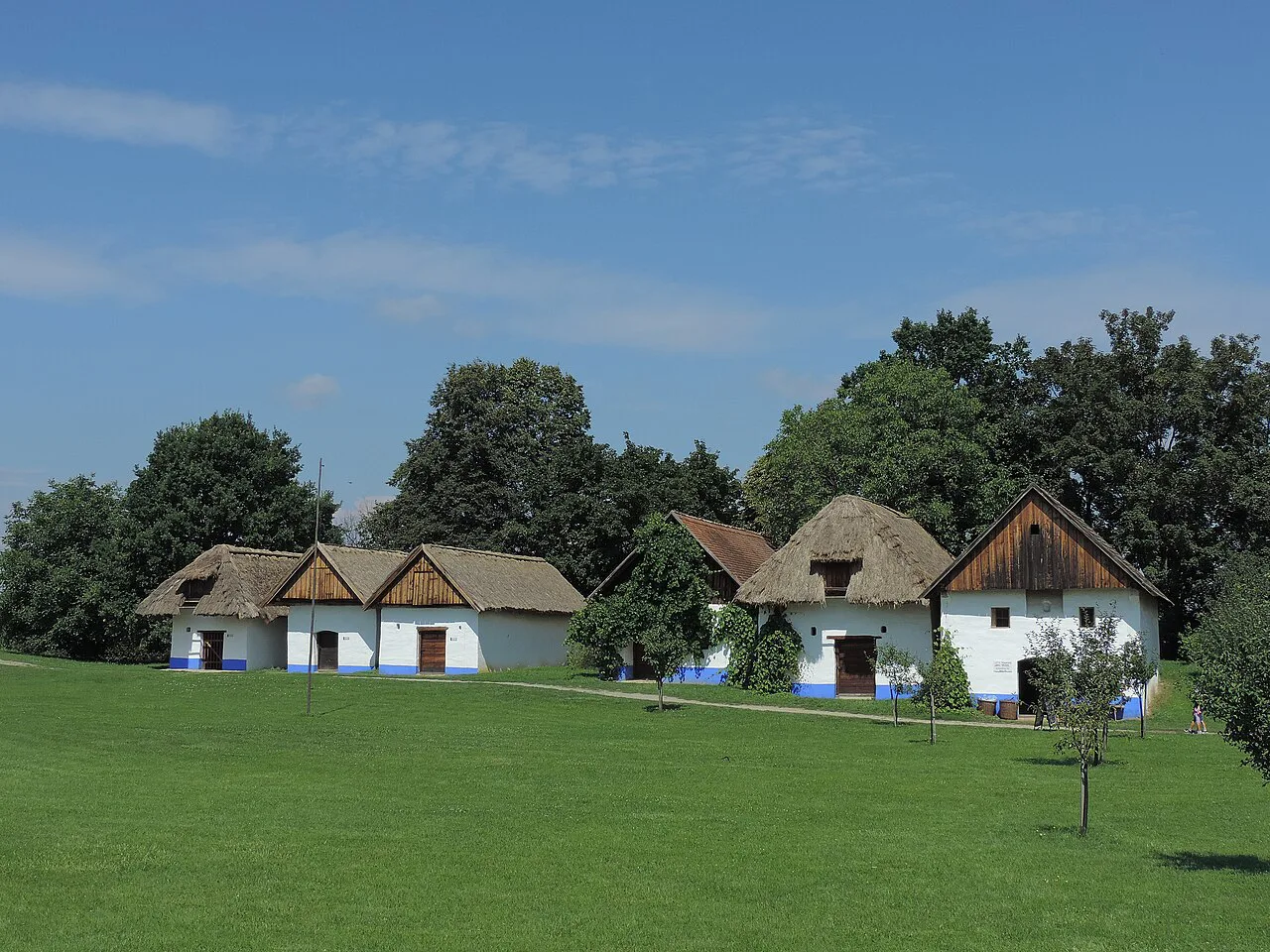 Thatched village houses on the green at the Strážnice open-air museum.