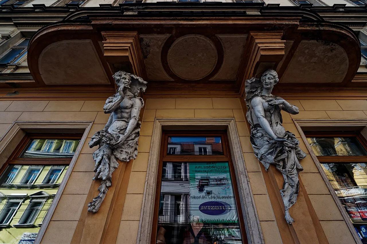 Sculpted figures framing a window on a Secession-era facade on Masarykova třída, Teplice.