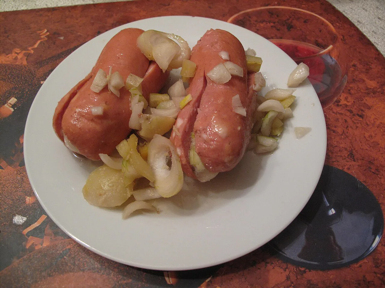 Utopenci pickled sausages served with sliced onion.