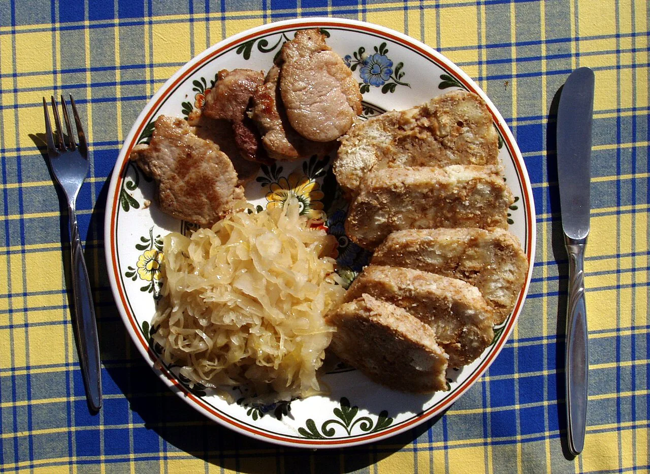 A plate of roast pork with sauerkraut, a classic Czech vepřo knedlo zelo.