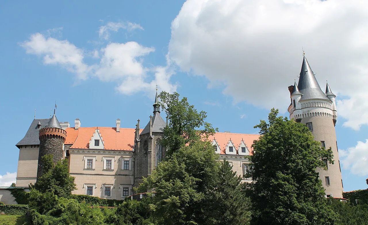 Žleby Castle and its towers rising above the trees.